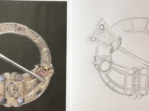 A hand holding a pencil, sketching the Hunterston brooch.