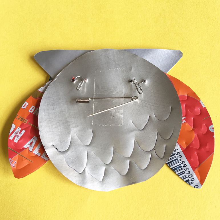 A stylish owl badge crafted from a fizzy drink can.