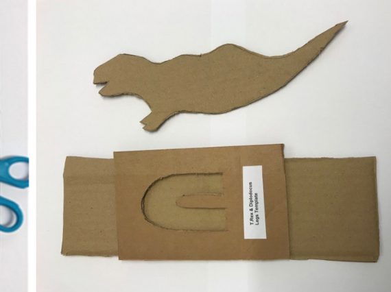 Three stages of making a cardboard dinoasaur, from drawing the outline on card to cutting it out.