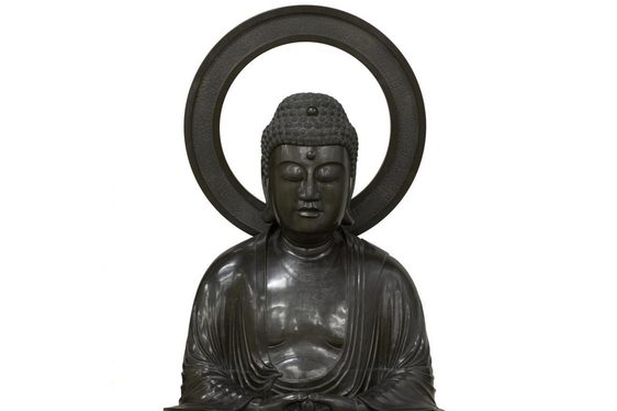 Bronze sculpure of the Buddha Amida seated in meditation with a mandorla behind his head.