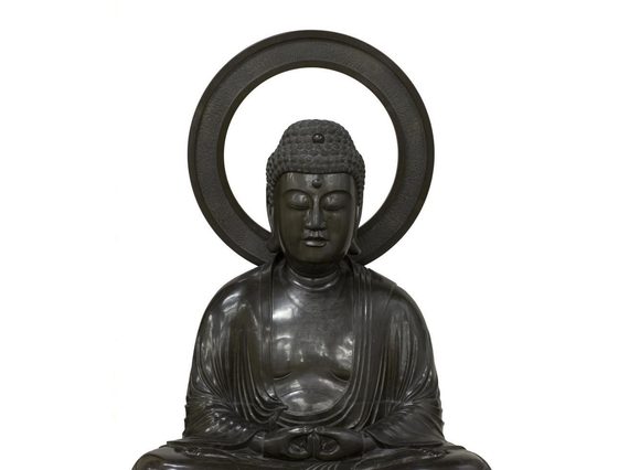 Bronze sculpure of the Buddha Amida seated in meditation with a mandorla behind his head.