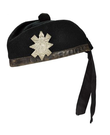 A woollen bunnet with a bauble on top and ribbons hanging down from it. Decorated with a silver badge.