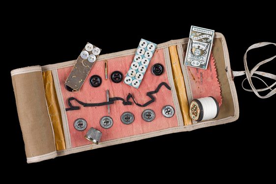 Small sewing kit with buttons, thread, needles and thimble.