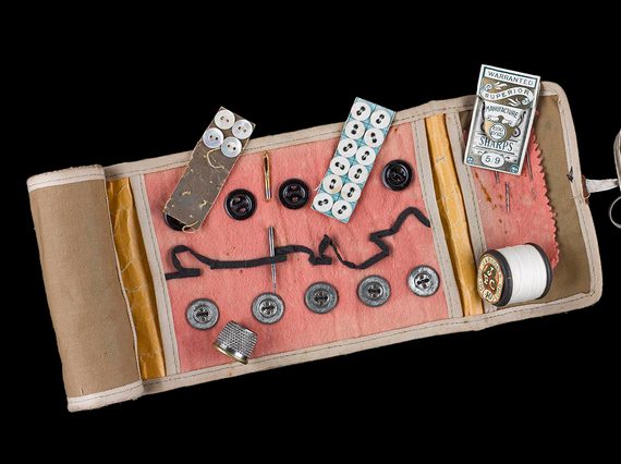 Small sewing kit with buttons, thread, needles and thimble.