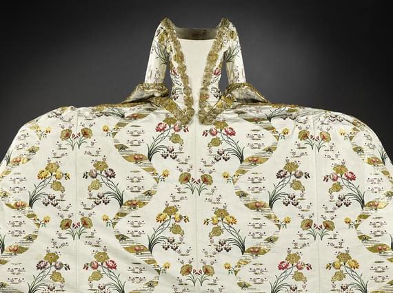 An extravagant gown with a wide skirt and complex pattern designs.